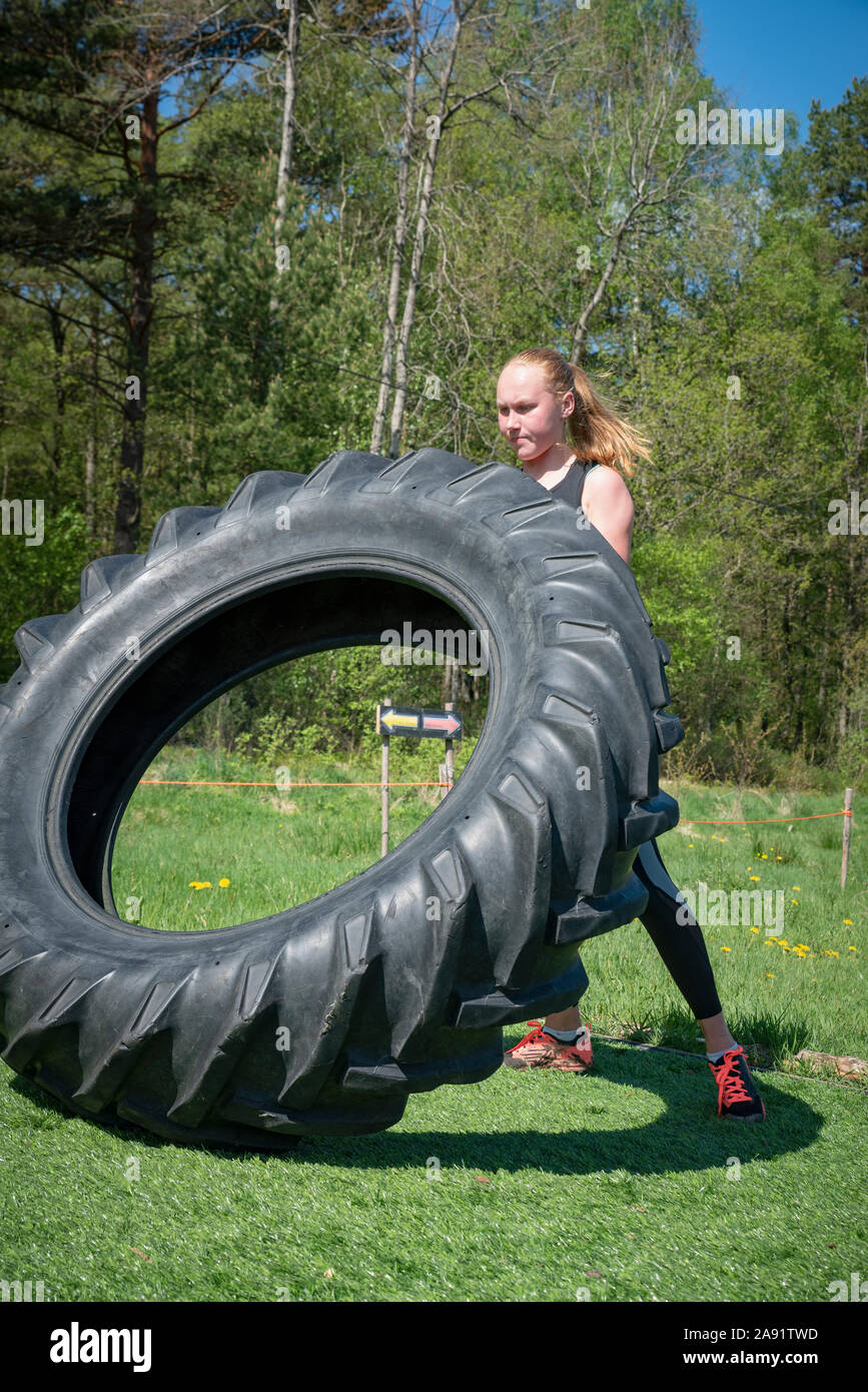 Teenage girl training with tire Stock Photo