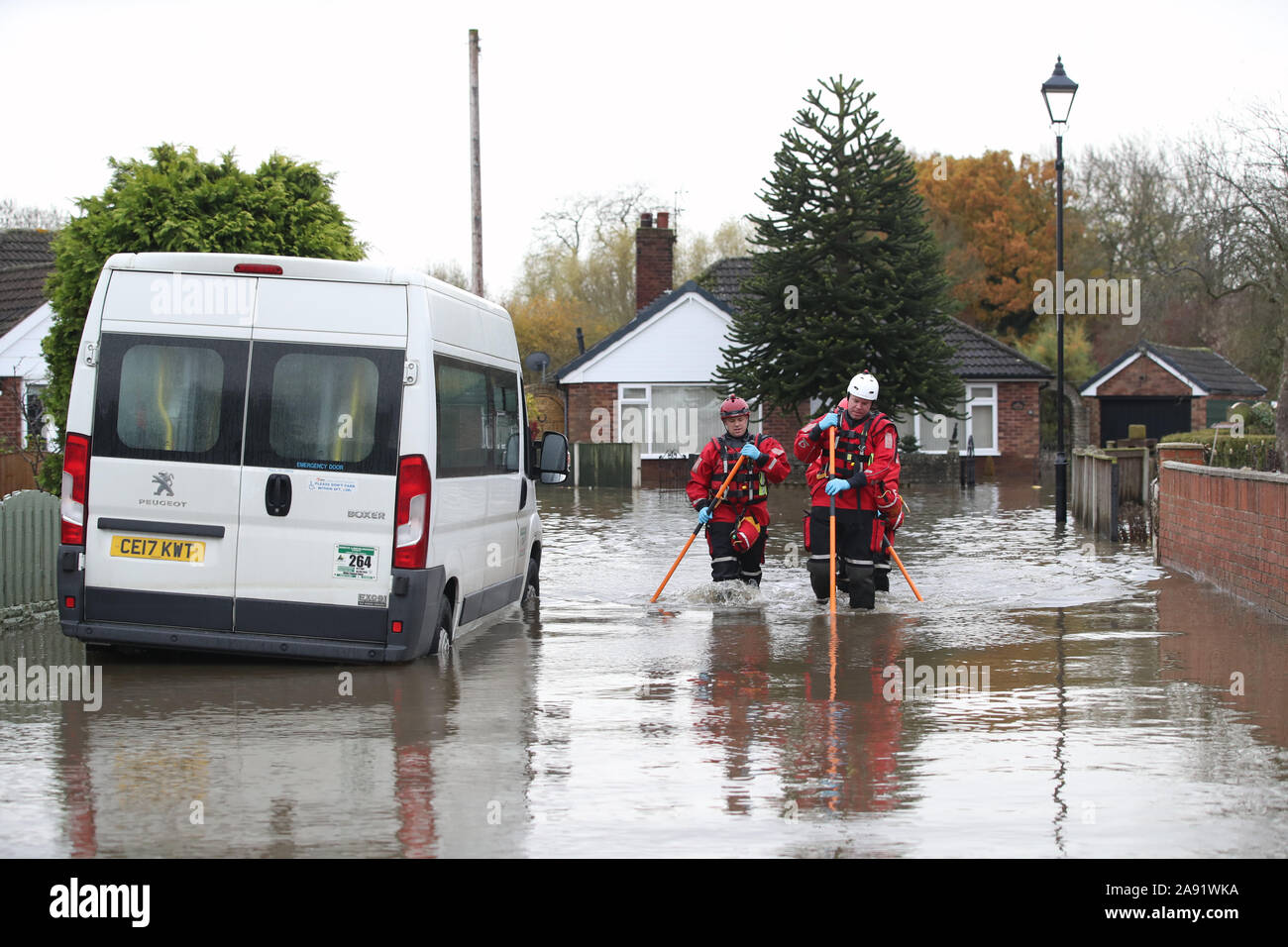 Rescuers walk through floodwater outside a house in Fishlake, Doncaster. The Prime Minister is set to chair a meeting of the Government's emergency committee after severe flooding in parts of the country, where rain is finally expected to ease this afternoon. Stock Photo