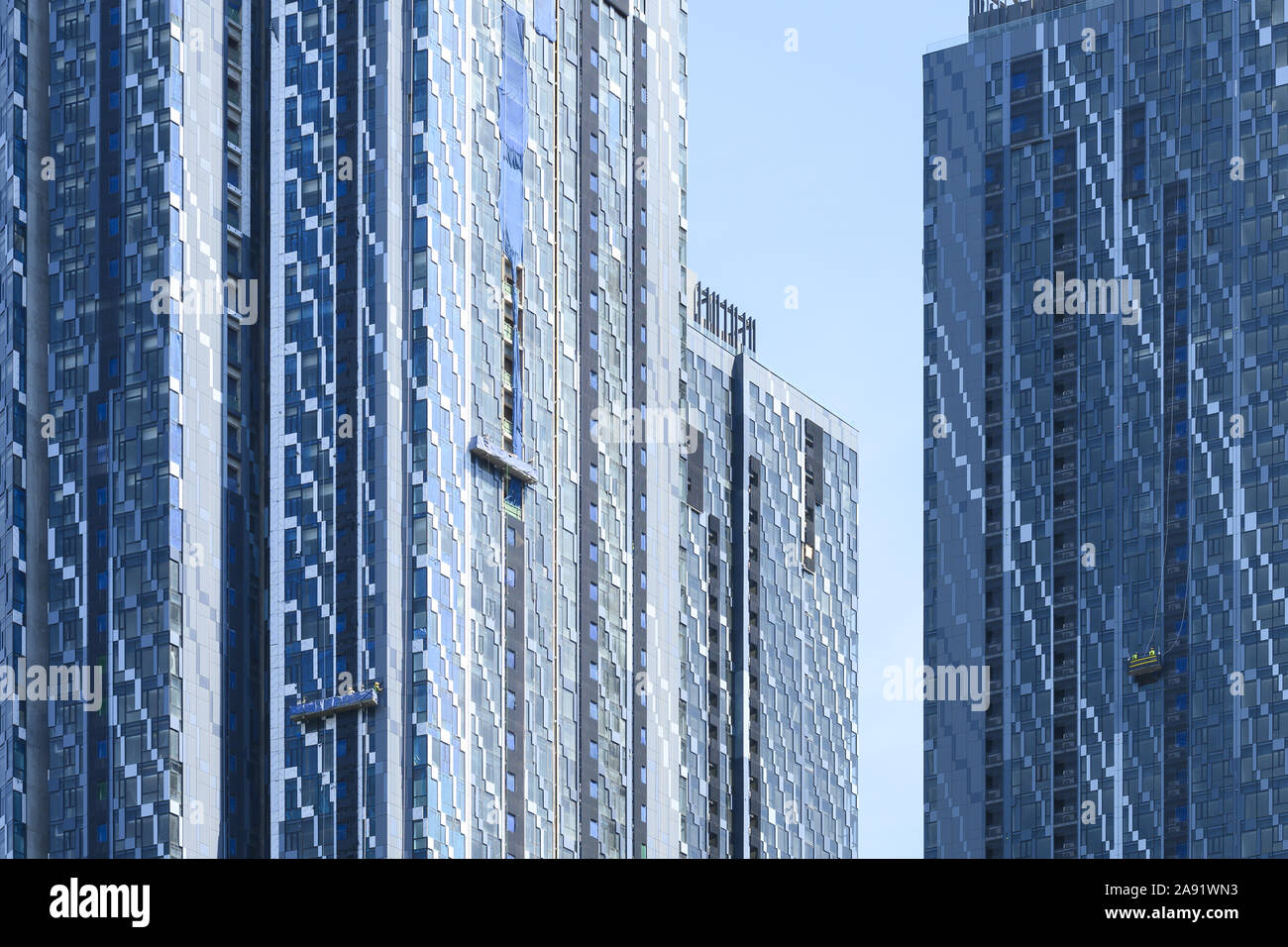 Close-up view of some modern skyscrapers with some window washer working on a suspended platform in Kuala Lumpur, Malaysia. Stock Photo