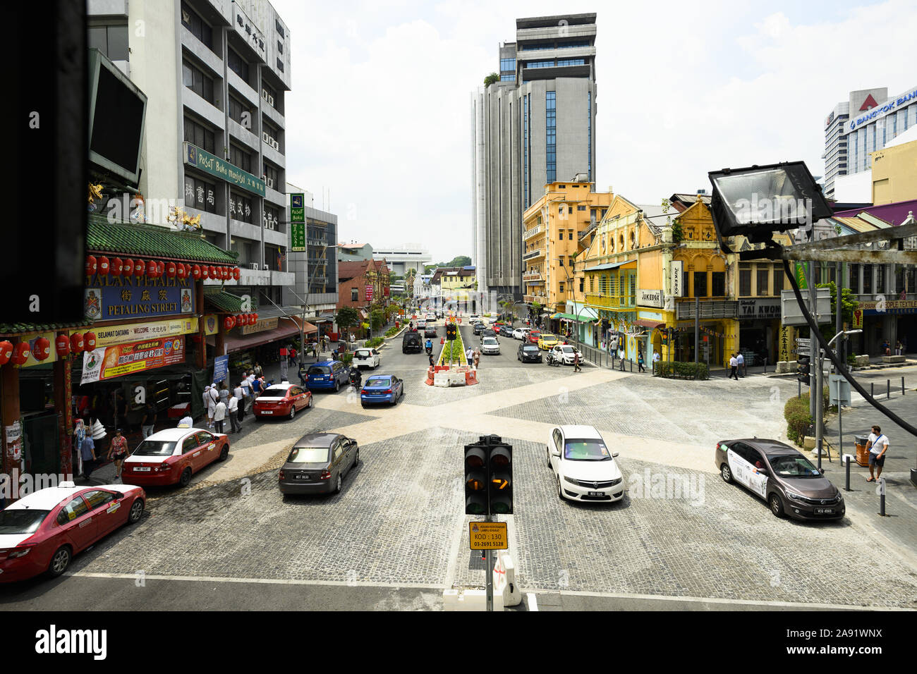 Daily life with traffic and people walking in Petaling Street during a sunny day. Stock Photo