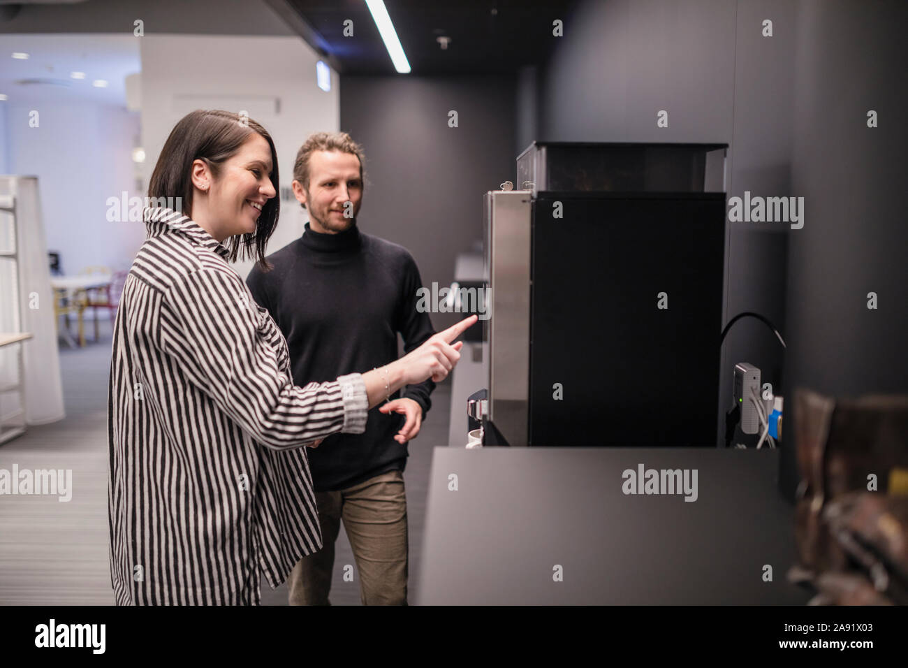 Smiling colleagues preparing coffee Stock Photo