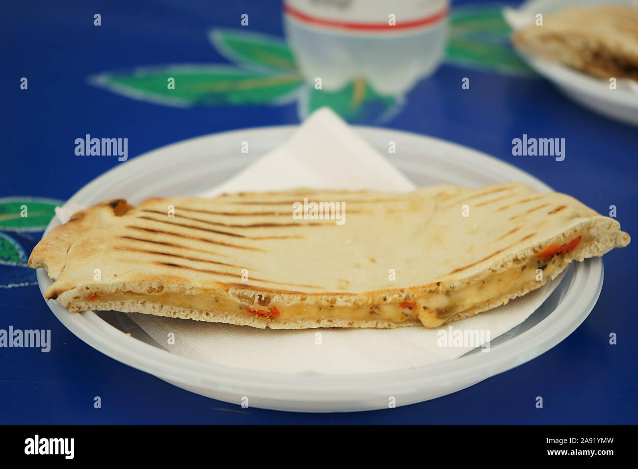Flat bread - Piadina romagnola sandwich with tomato and cheese on plastic dish Stock Photo