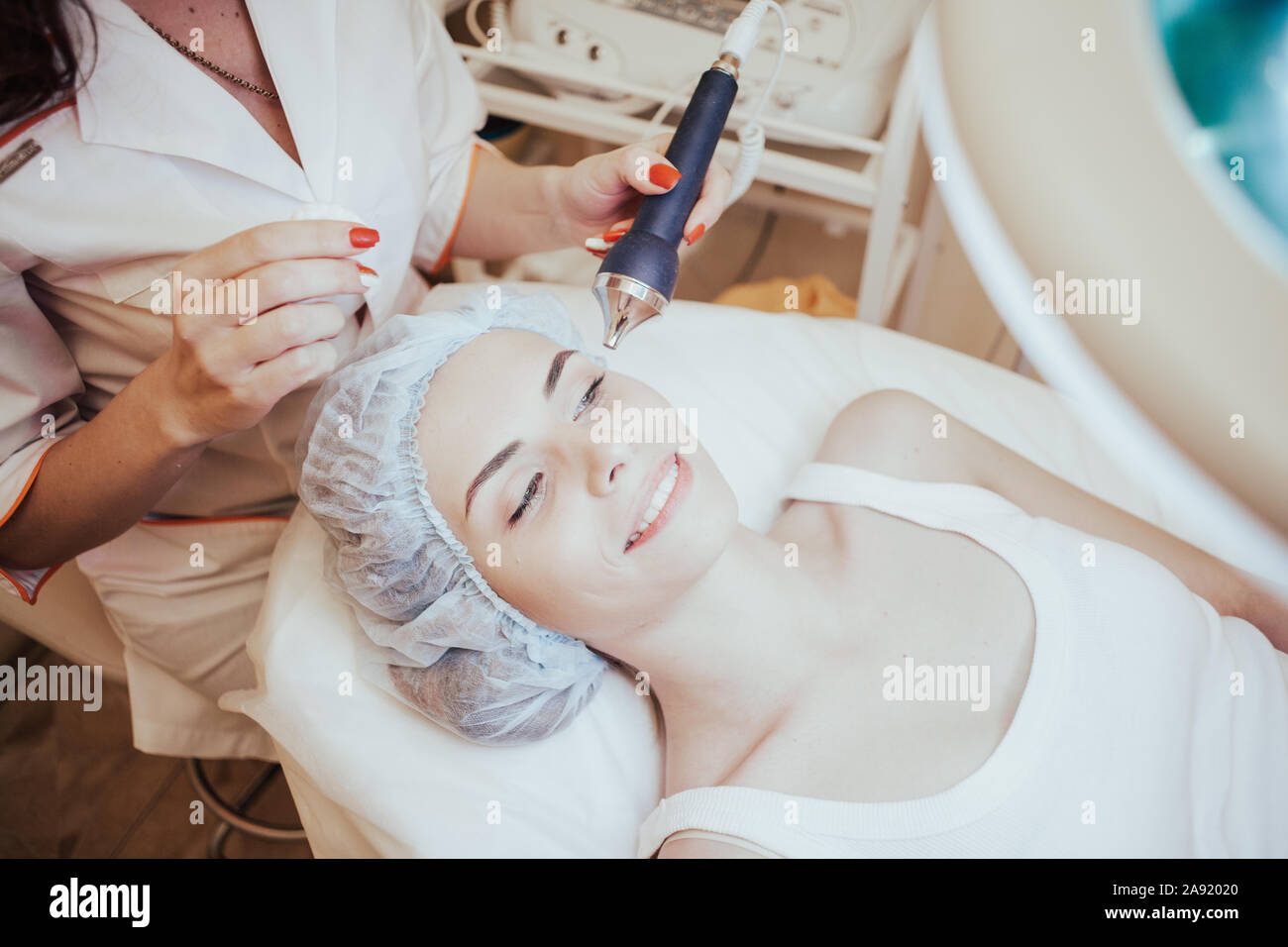 Cosmetology doctor makes the procedure a woman face cleaning Stock Photo