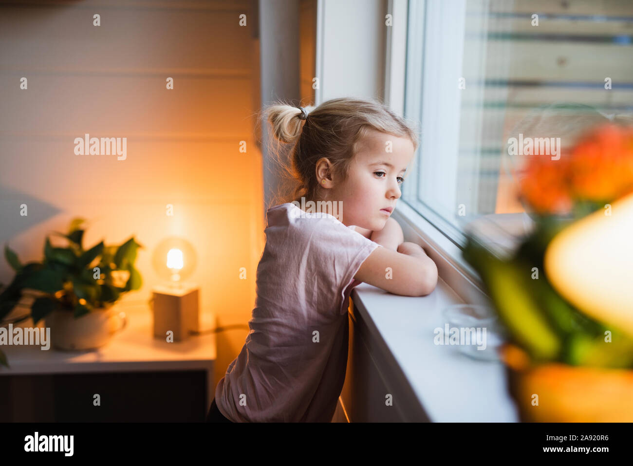 Girl looking through window Stock Photo