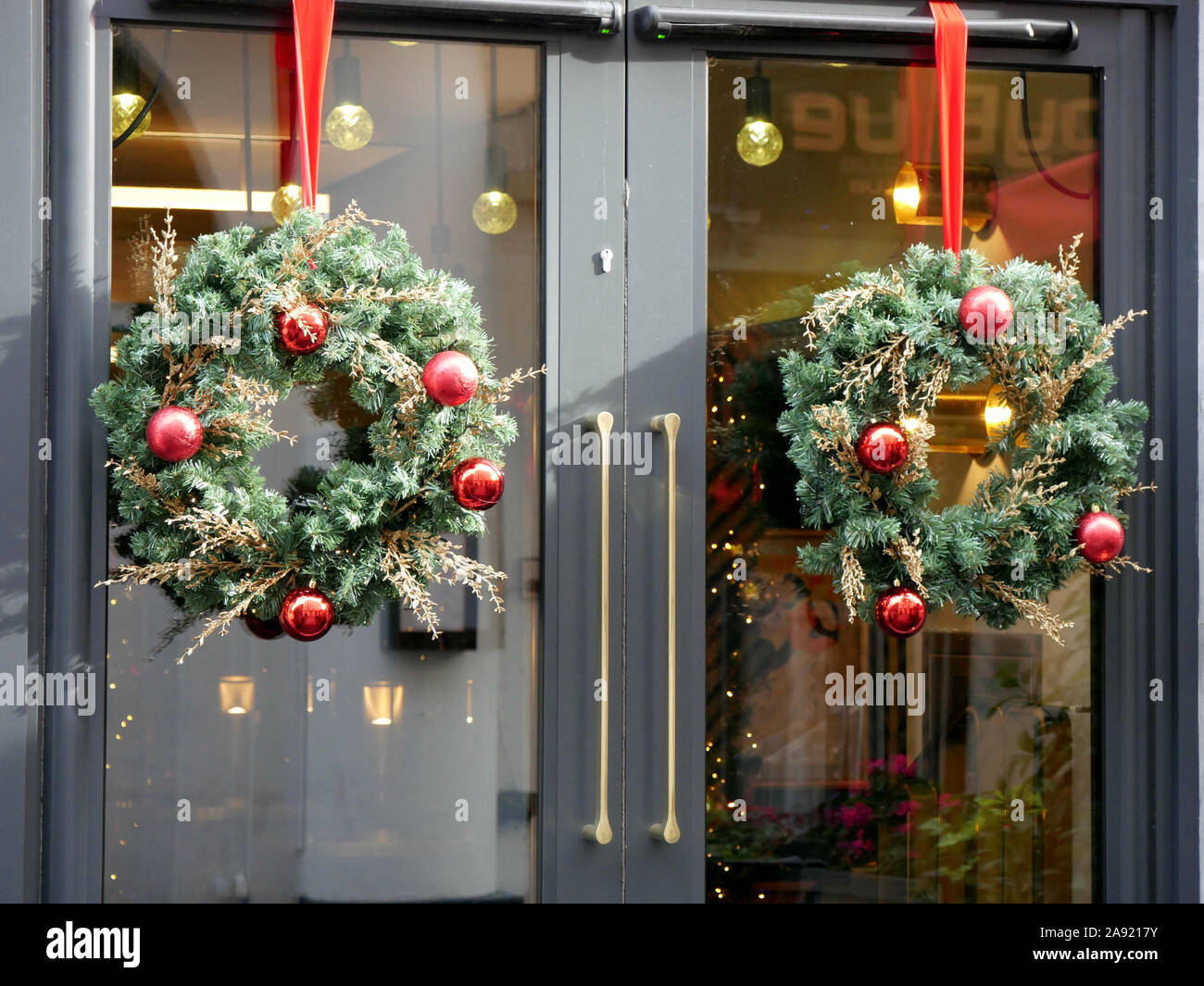 Two Christmas wreaths hanging on office doors Stock Photo Alamy
