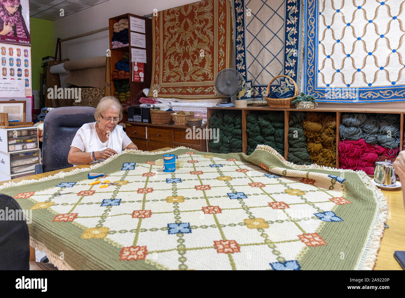 Carpet Restoration.  The University Town of Coimbra, Portugal.  One of a few remaining specialists restores an antique carpet Stock Photo