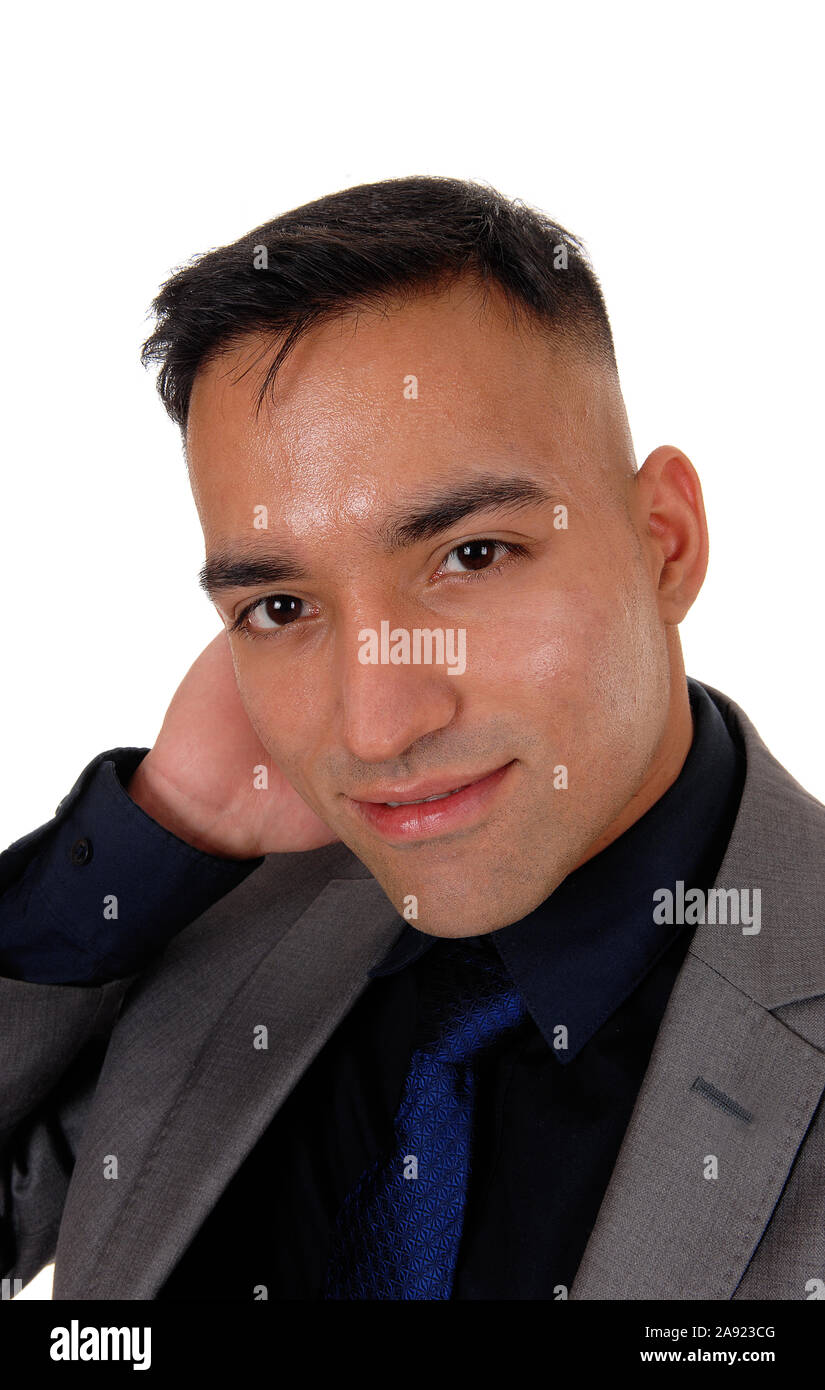 A closeup image of a handsome young east Indian man in a gray suit, black shirt and blue tie, isolated for white background Stock Photo