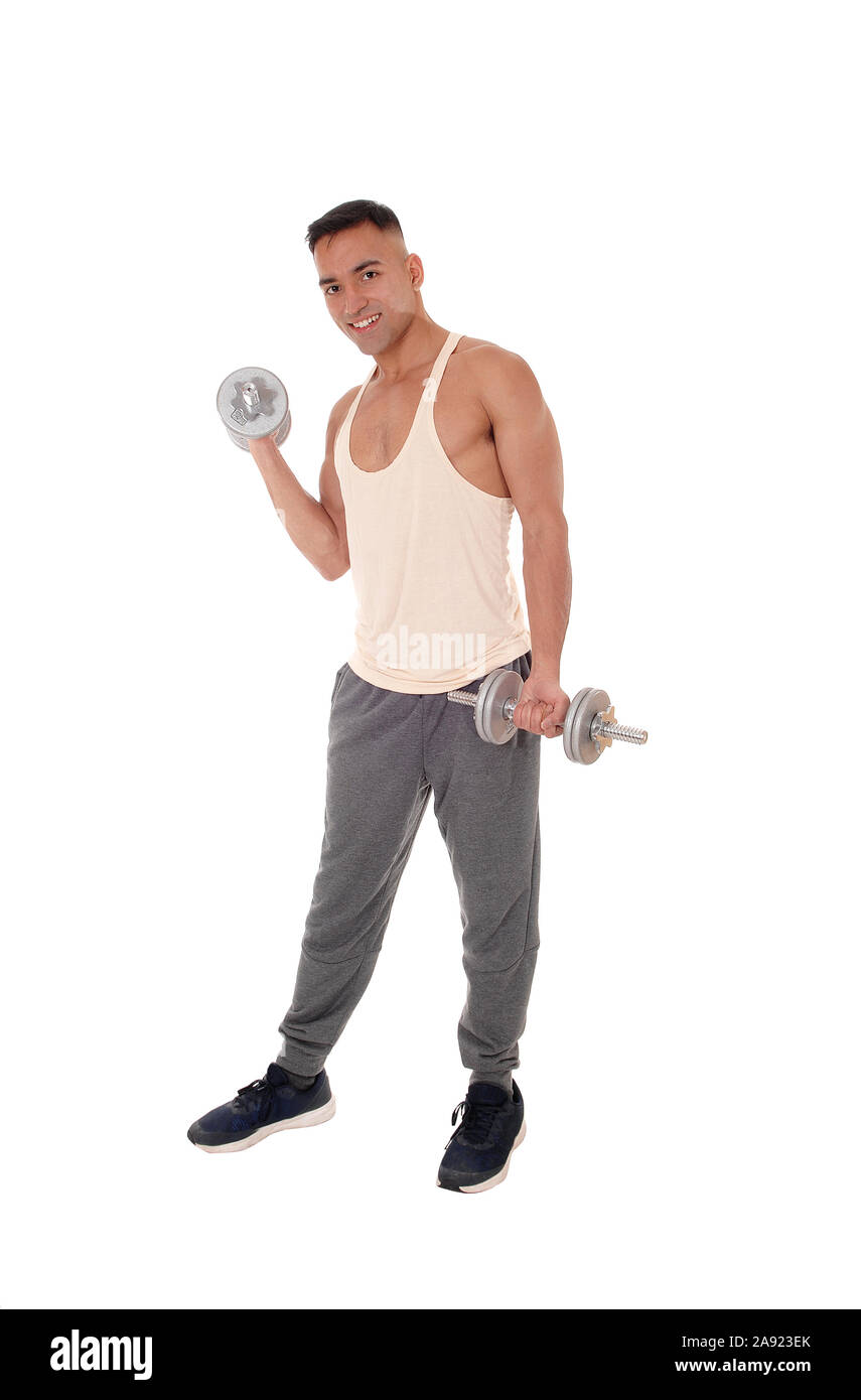 A handsome east Indian man standing in track pants working with two dumbbells, isolated for white background Stock Photo