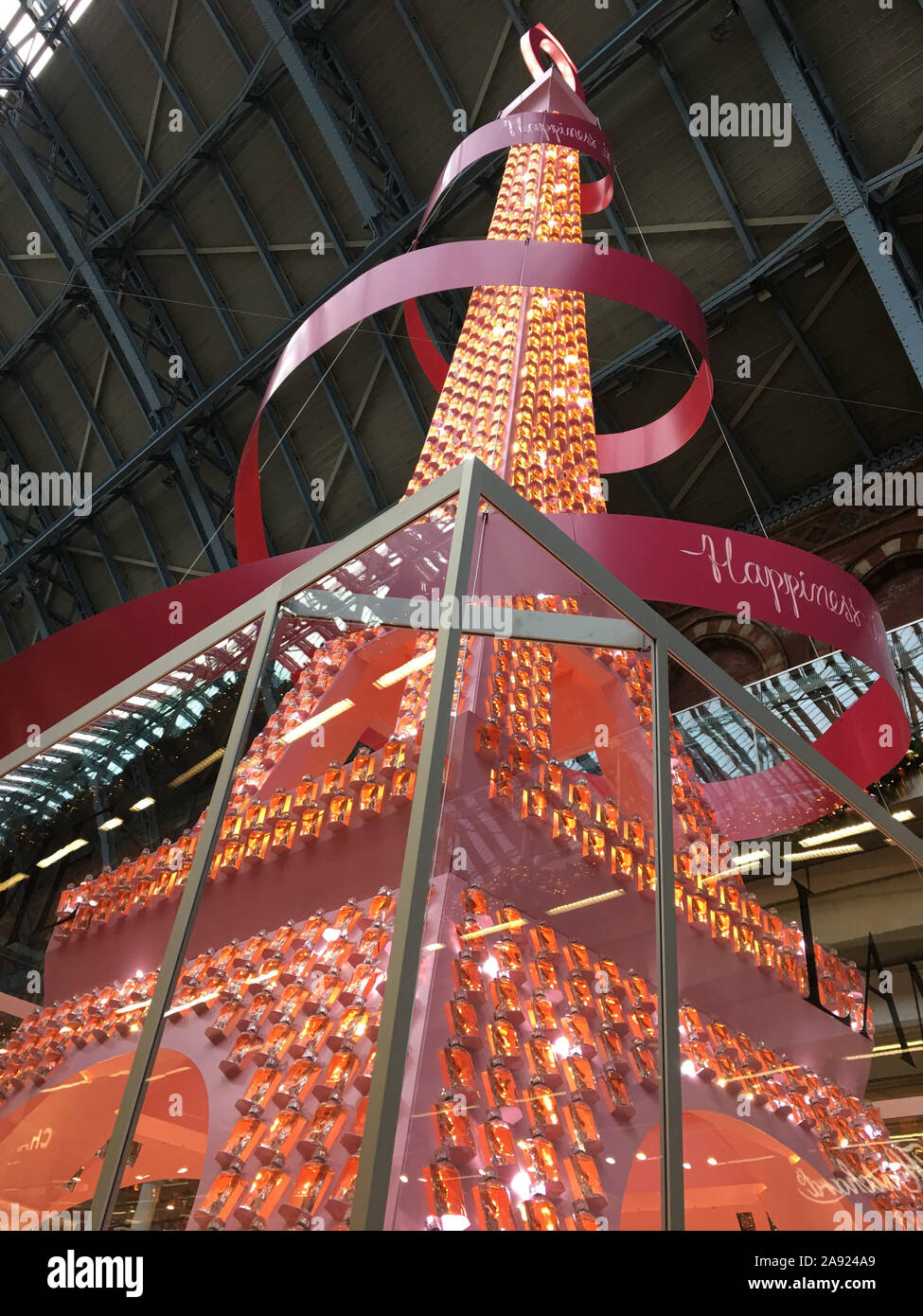 The 36-foot-tall sparkling installation of perfume bottles on an Eiffel Tower-shaped Christmas tree in St Pancras station, London, which contains more than 1,500 bottles of Lanc??me's signature fragrance, 'La Vie Est Belle'. Stock Photo