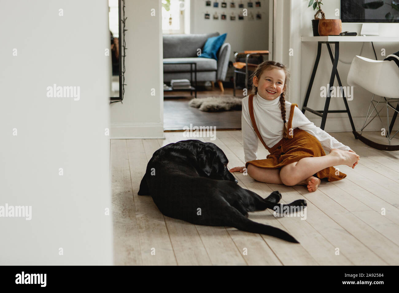 Smiling girl sitting on floor Stock Photo - Alamy