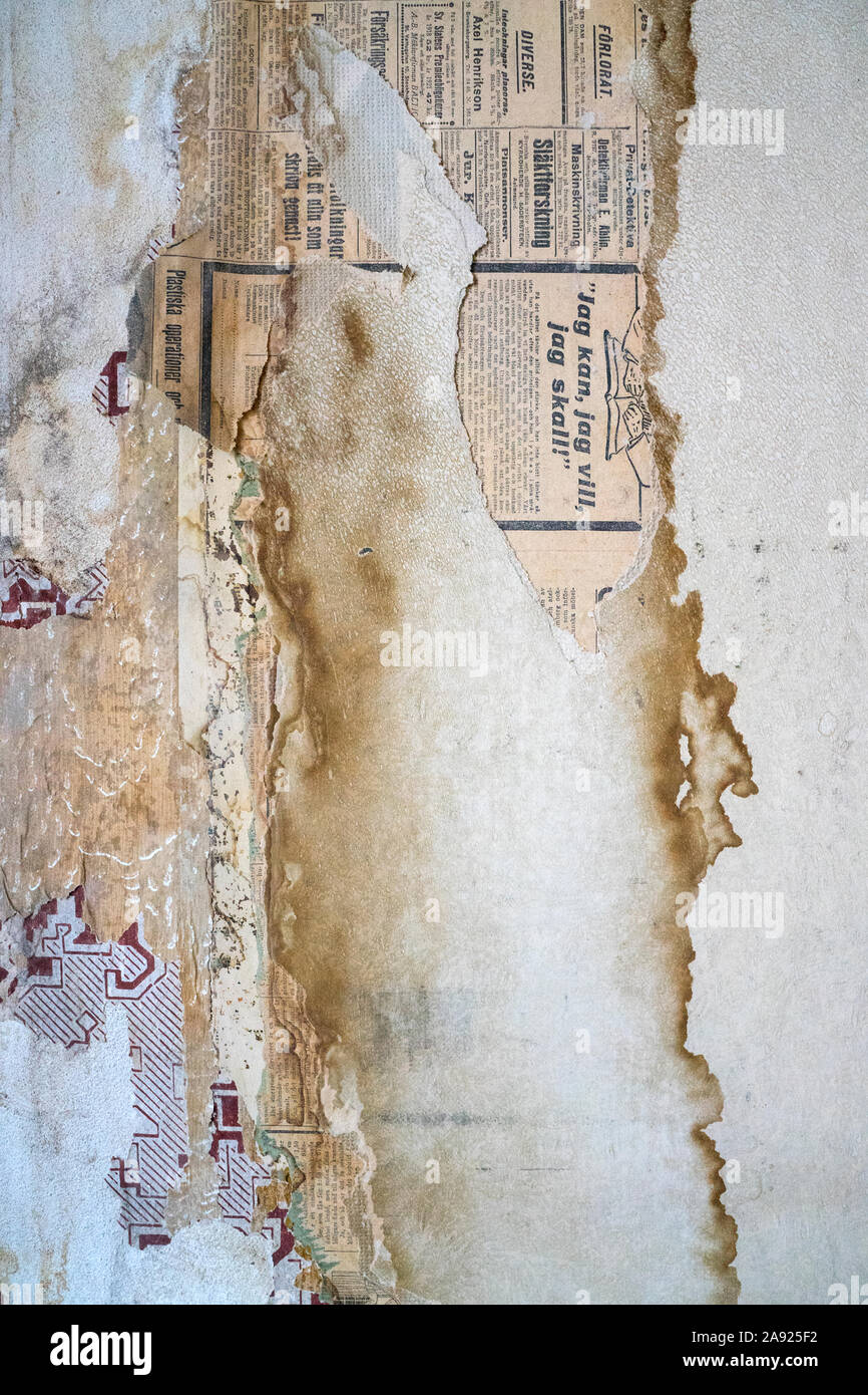 Stains and newspaper on wall, close-up Stock Photo