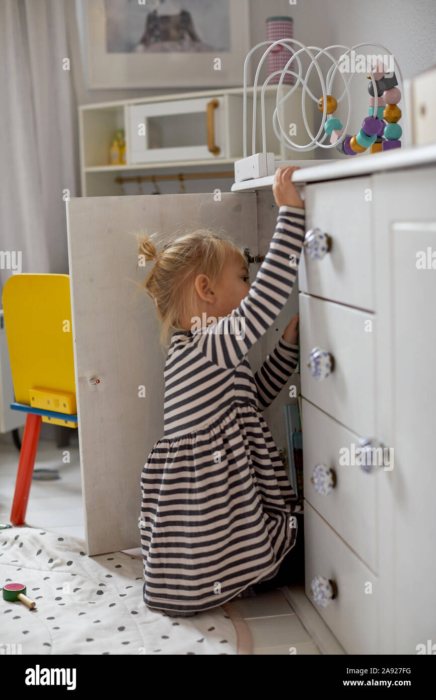 Girl looking into cupboard Stock Photo Alamy