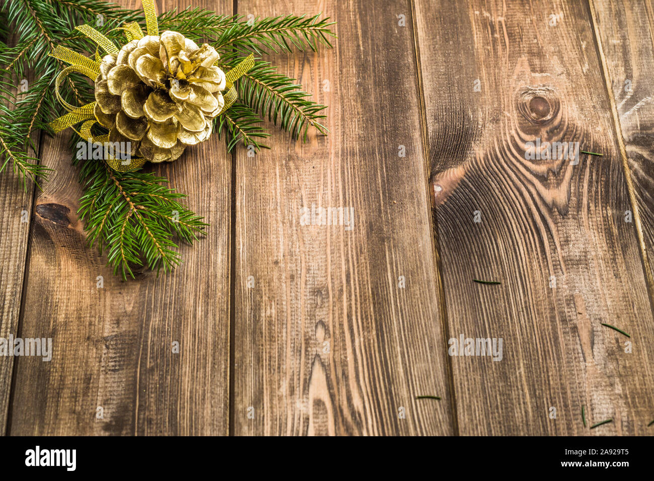 Wooden background with christmas decoration, pine cone hanging on branch of christmas tree Stock Photo