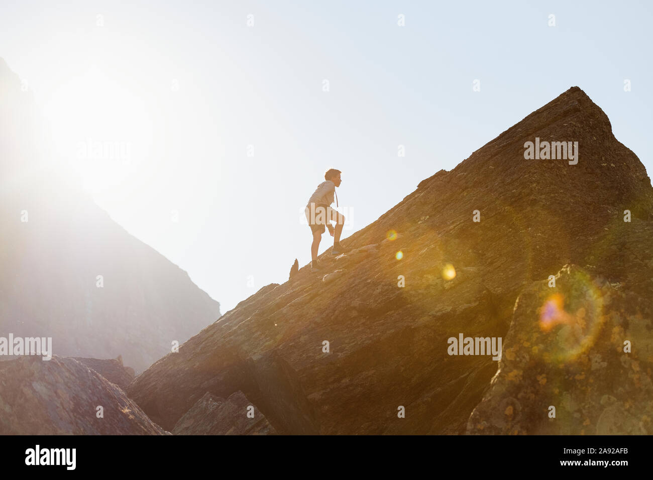 Boy climbing mountain Stock Photo - Alamy