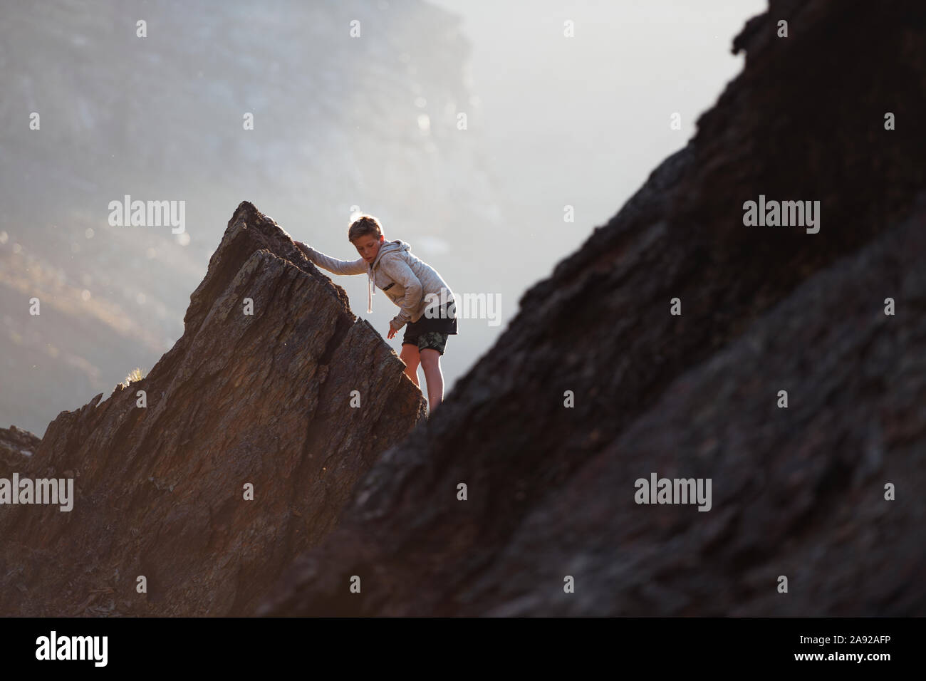Boy climbing mountain Stock Photo - Alamy