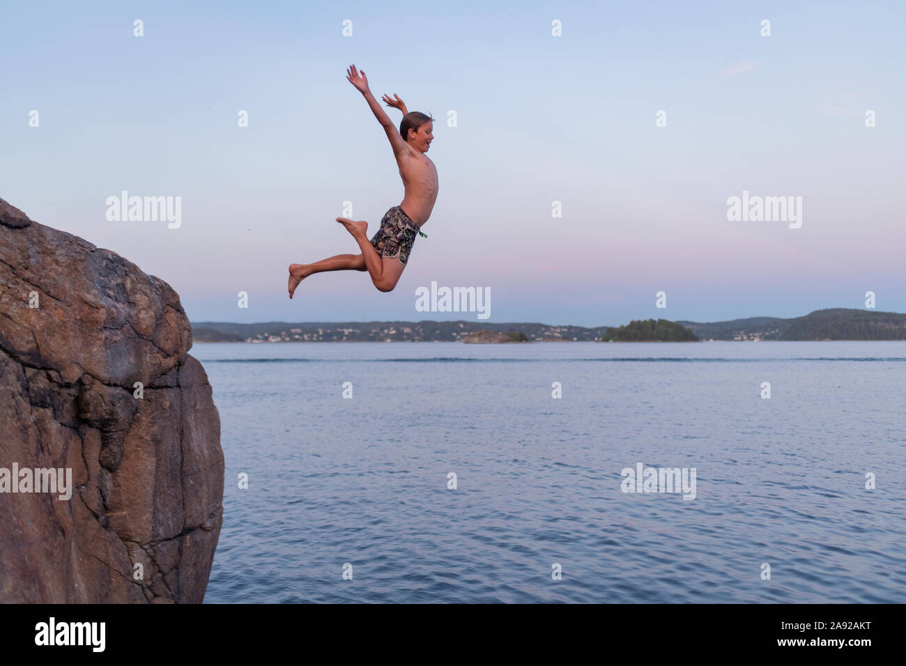 Boy jumping into sea Stock Photo