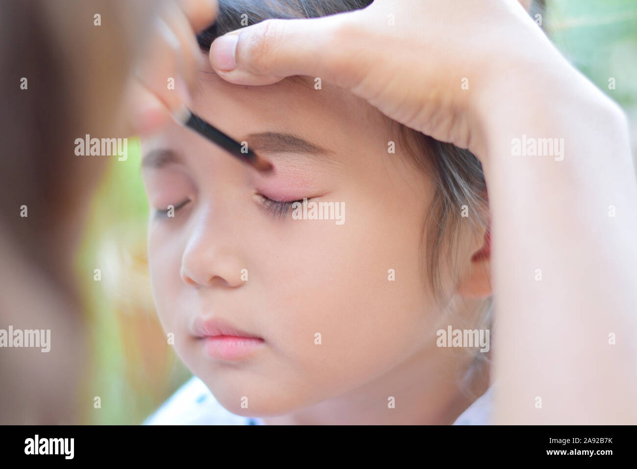little girl getting her face for makeup by makeup artist Stock Photo