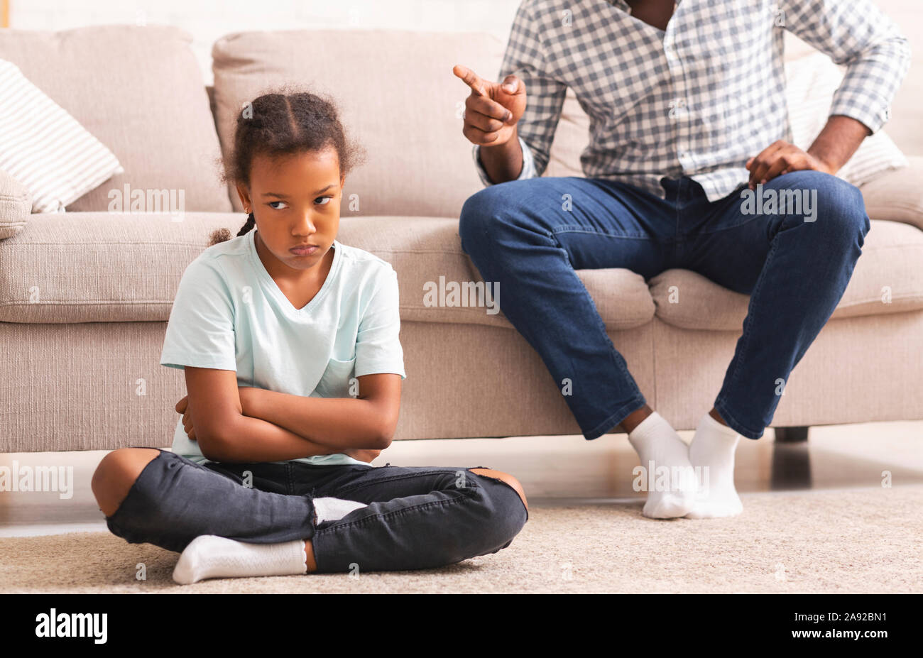 Strict afro father scolding little disobedient daughter for bad behavior Stock Photo