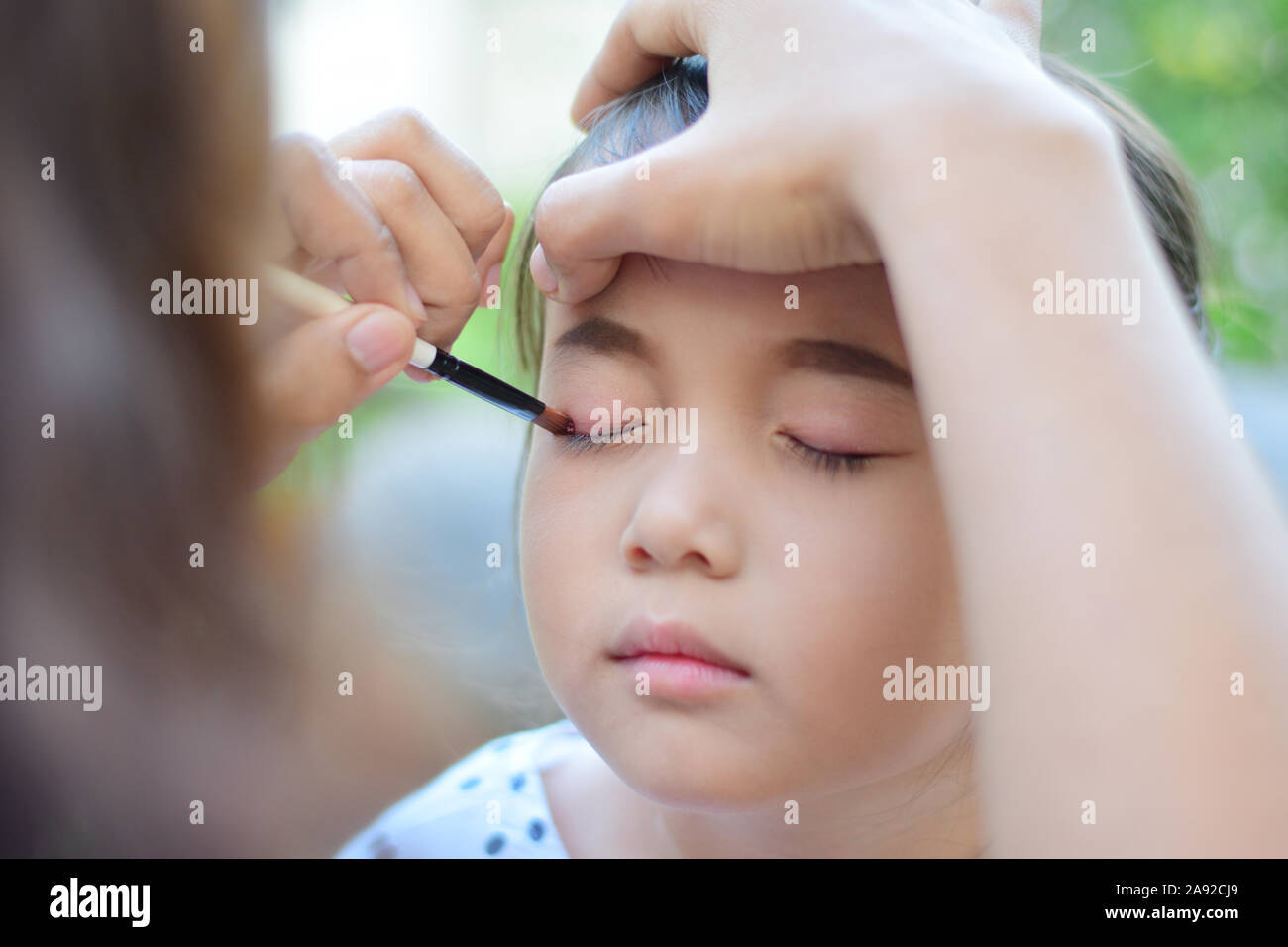 little girl getting her face for makeup by makeup artist Stock Photo