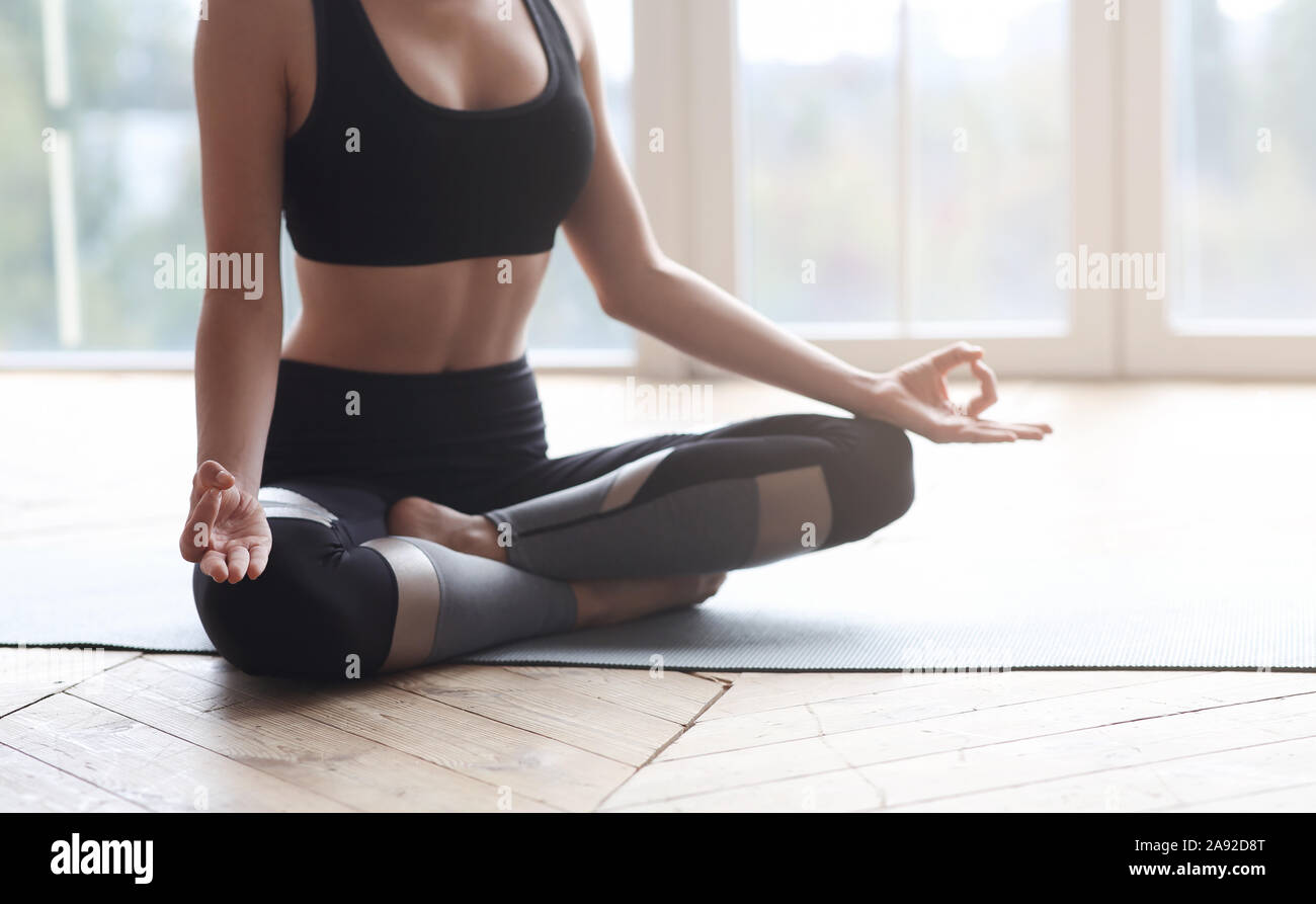 Cropped of yoga girl sitting in lotus pose Stock Photo - Alamy
