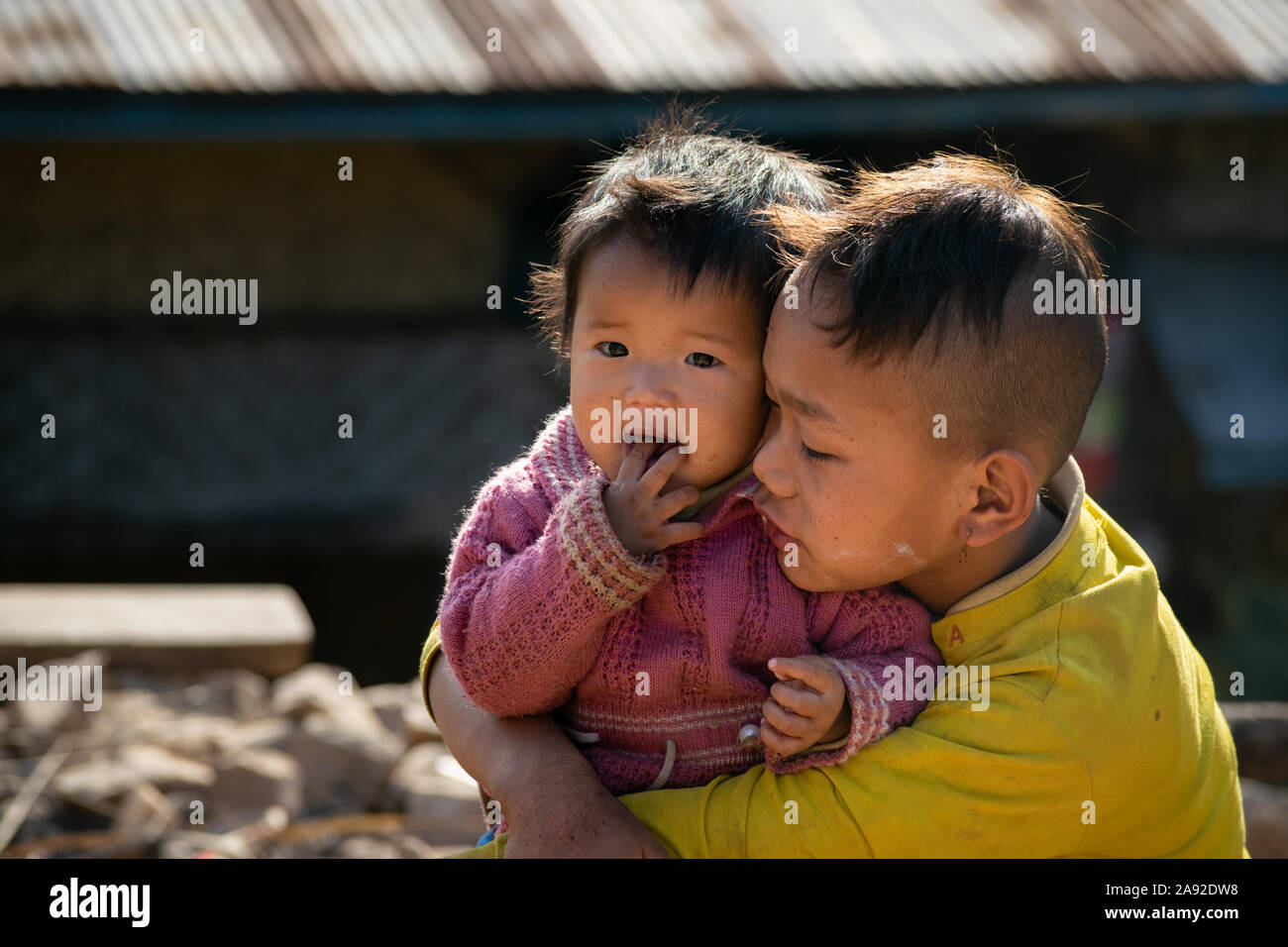 Young Burmese boy taking care of his sibling, Shan State, Myanmar Stock Photo