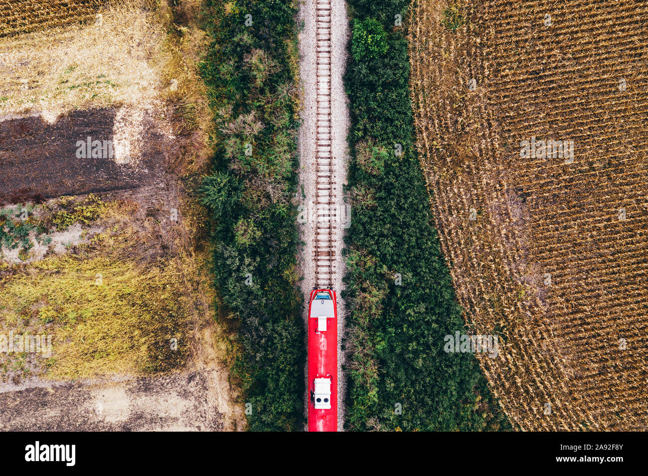 Aerial view of passenger train on railway through autumn countryside  landscape, top view from drone pov Stock Photo - Alamy