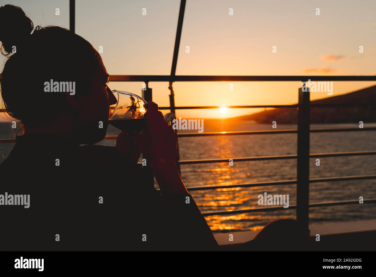 Woman having drink at sea Stock Photo