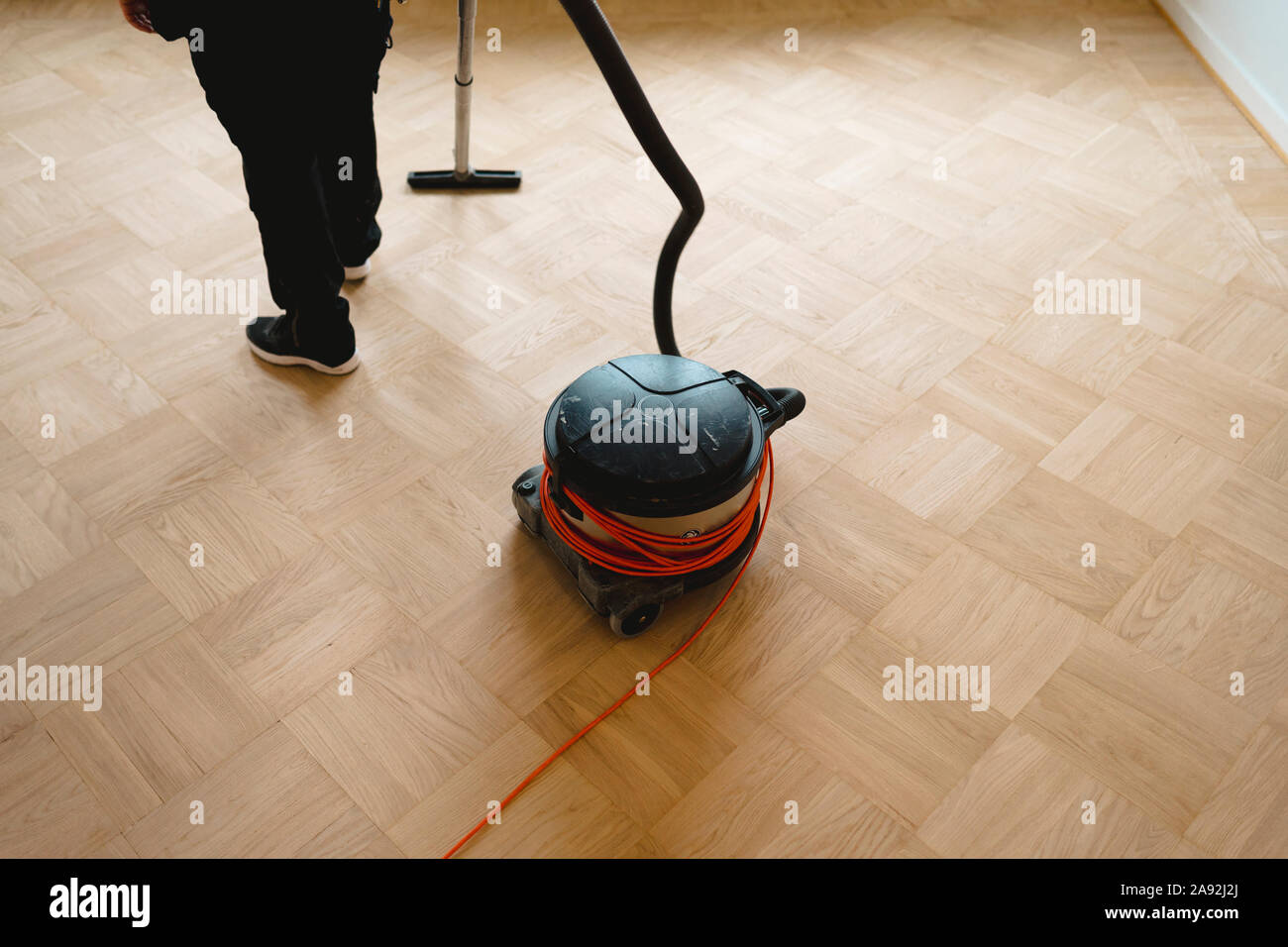Vacuuming parquet floor Stock Photo