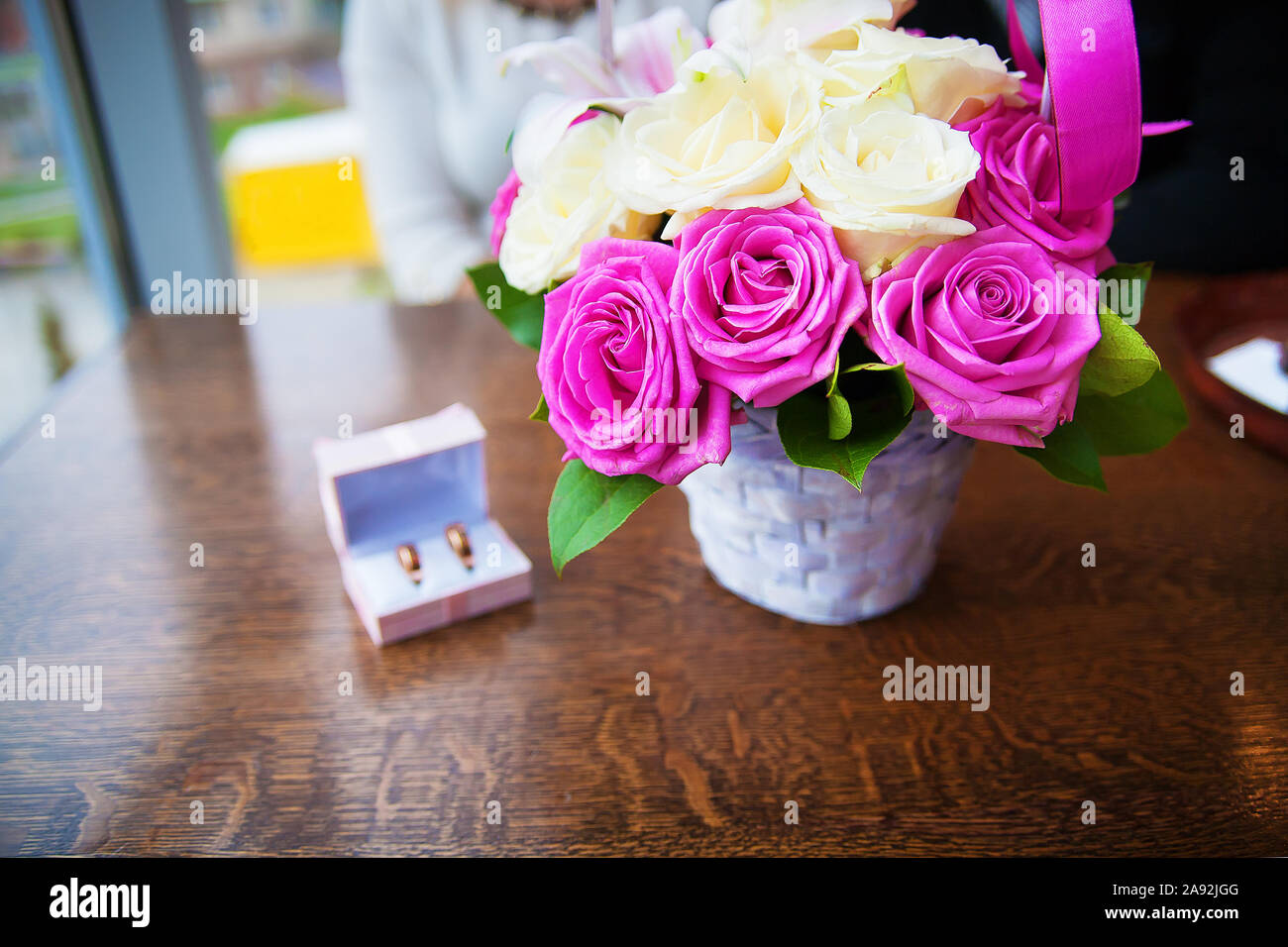 bouquet of beautiful and colorful flowers and wedding rings in a box ...