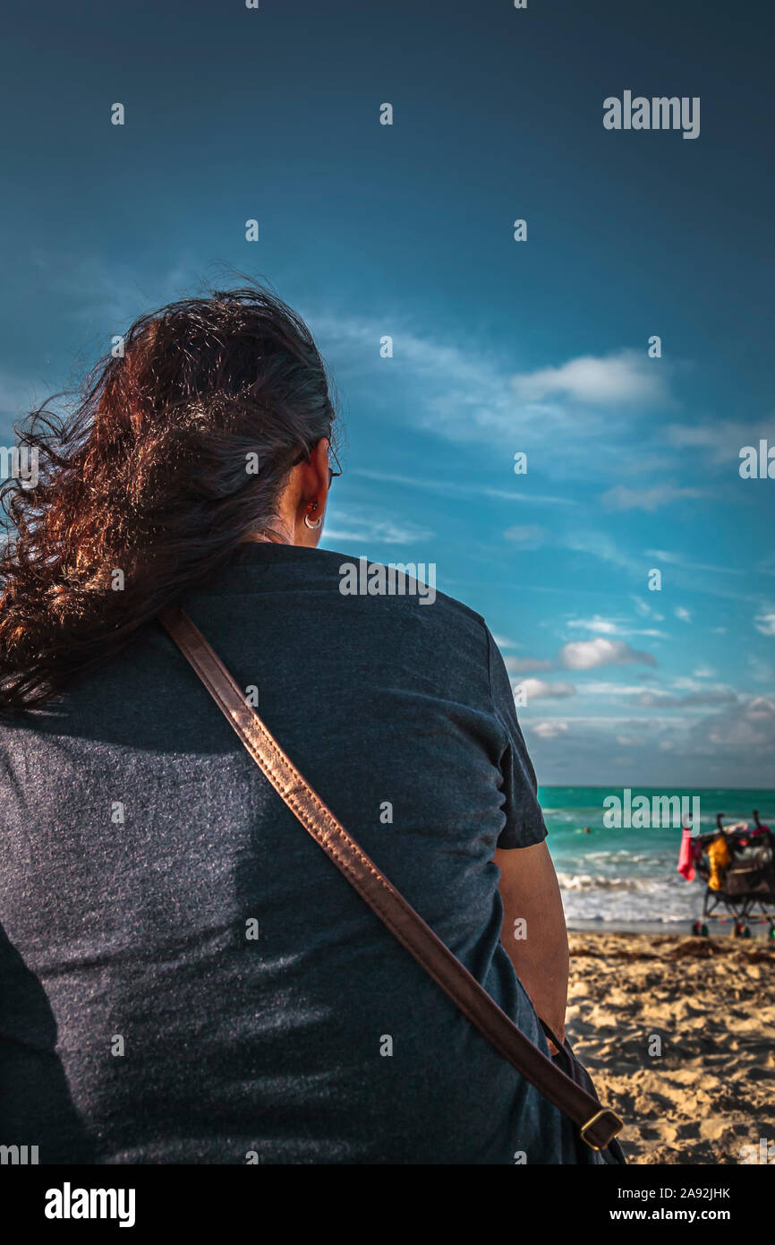 Varadero beach, Cuba, Jan 2013 - Woman sitting on the sandy beach enjoys the seascape Stock Photo