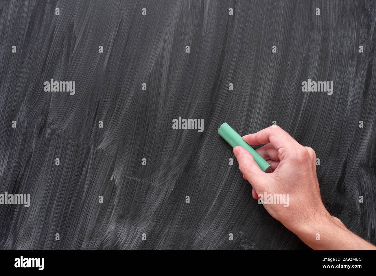 Hand writing on a black chalkboard with green chalk. Close up. Stock Photo