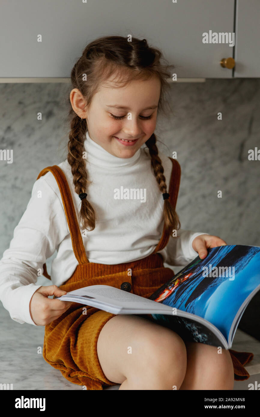 Smiling girl reading book Stock Photo