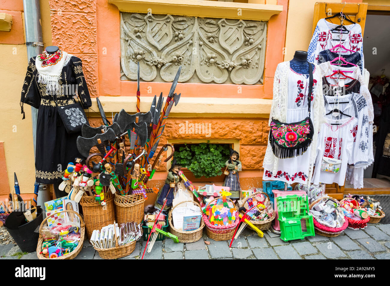 Variety of goods for sale on display on a sidewalk outside a shop; Sighisoara, Mures County, Transylvania Region, Romania Stock Photo
