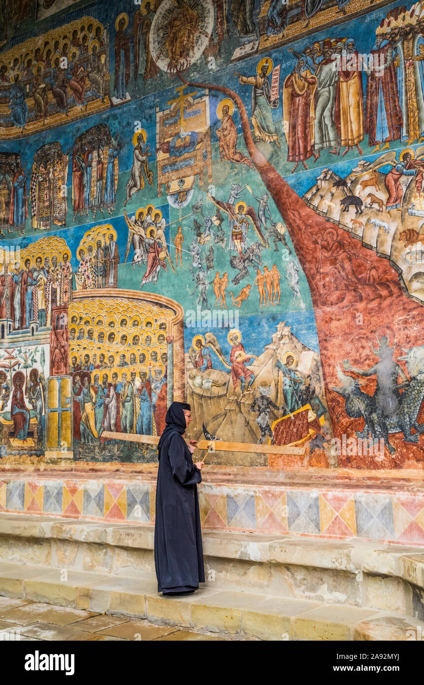 Nun viewing the 'Last Judgement' fresco, Voronet Monastery, 1487; Gura Humorului, Suceava County, Romania Stock Photo