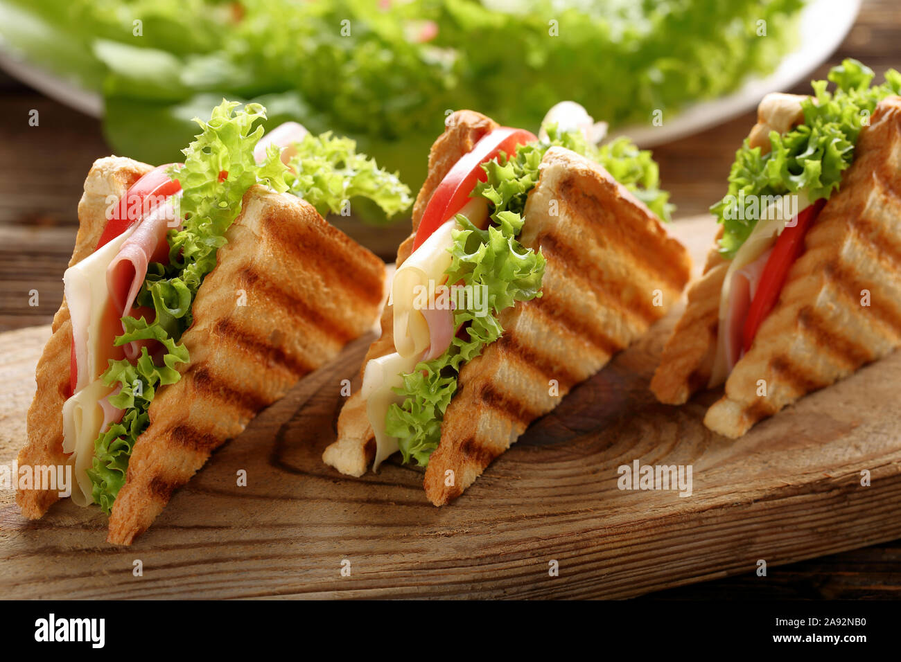 Fresh toast sandwich with cheese, ham and tomato on wooden background Stock Photo