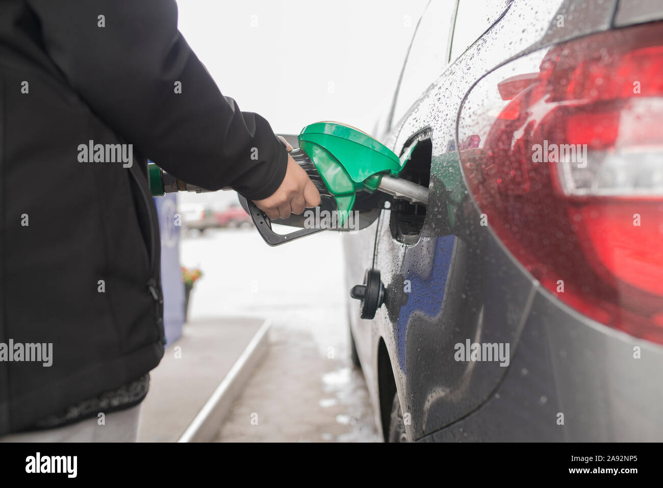 Hand holding fuel nozzle in car Stock Photo