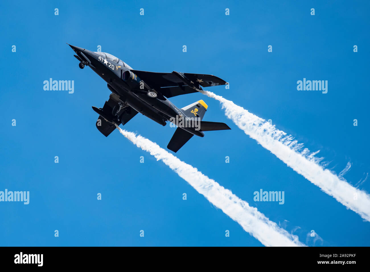 The 1981 DORNIER GMBH ALPHA-JET trailing smoke while performing aerobatic manoeuvres with landing gear down in the 2019 Olympic Air Show, Olympic A... Stock Photo