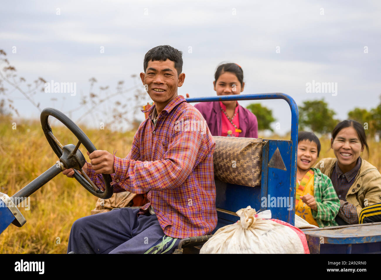 Family riding together in truck through farm fields; Taungyii, Shan State, Myanmar Stock Photo