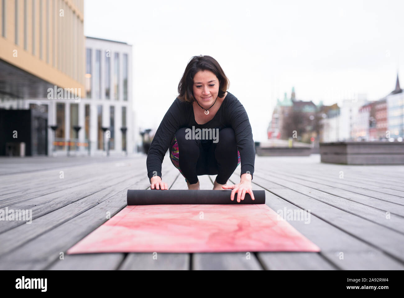 Woman rolling yoga mat Stock Photo