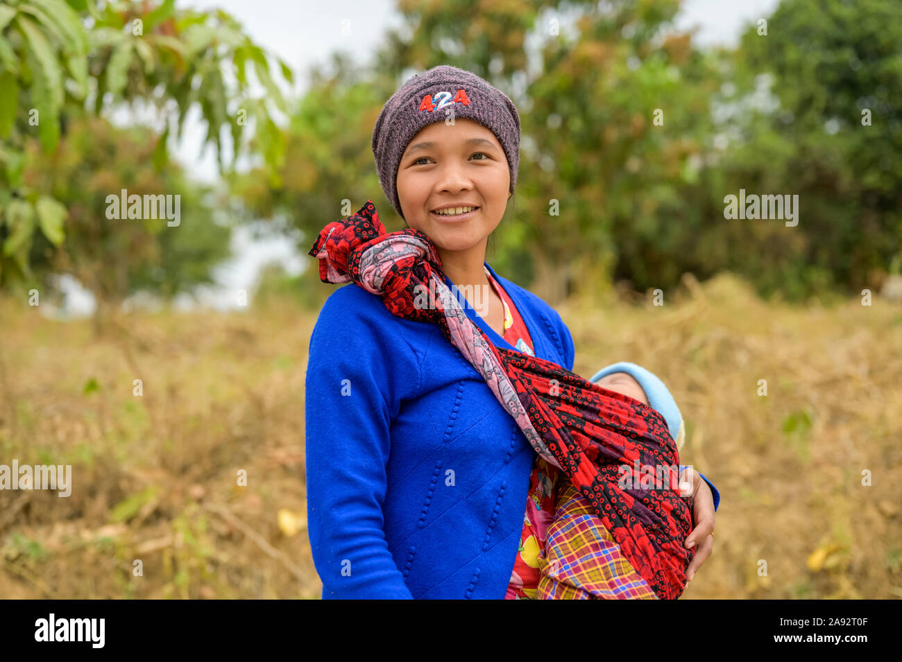 Young mother standing with her baby in a sling; Taungyii, Shan State, Myanmar Stock Photo