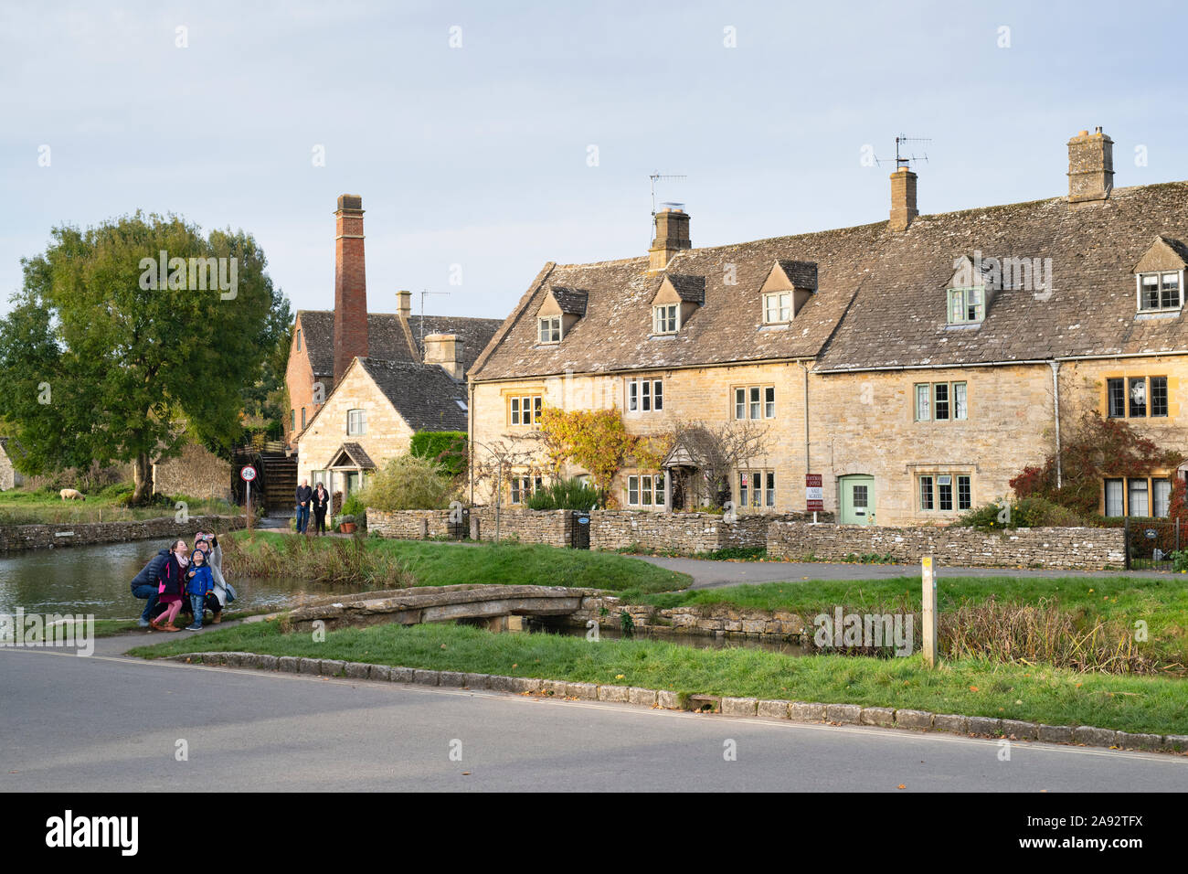 Family taking a selfie in Lower Slaughter in the autumn. Cotswolds, Gloucestershire, England Stock Photo
