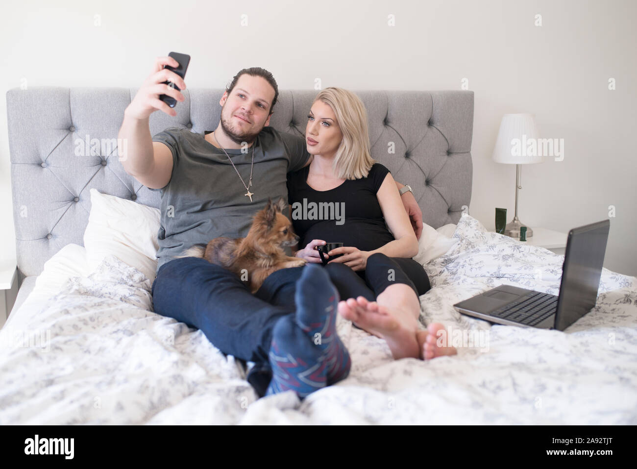 Couple on bed taking selfie Stock Photo