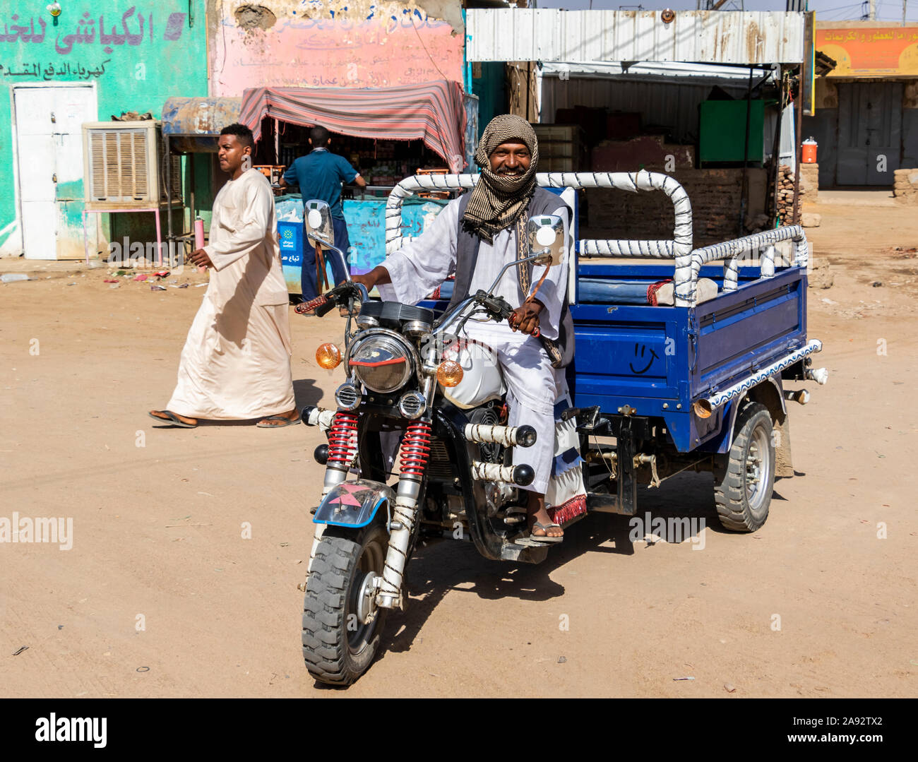 Sudanese man driving a motorized tricycle; Abri, Northern State, Sudan Stock Photo
