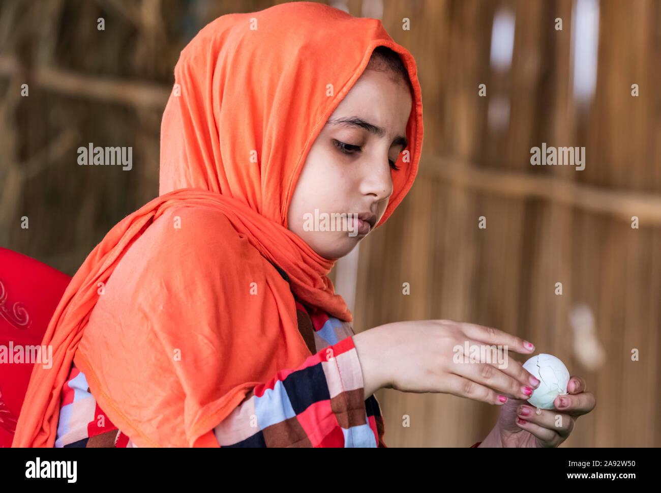 Sudanese girl peeling a boiled egg; Al Huqnah, Khartoum, Sudan Stock Photo