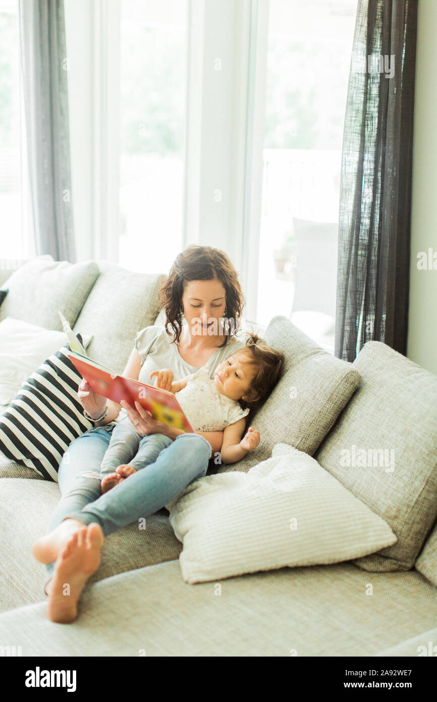 Mother reading childrens book with daughter Stock Photo
