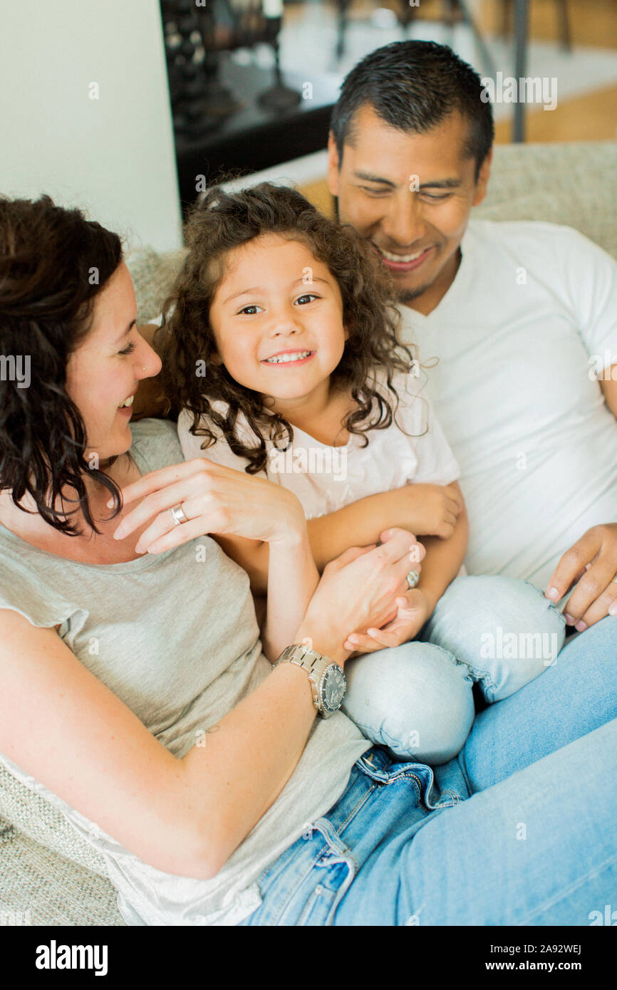 Parents with daughter sitting on sofa Stock Photo