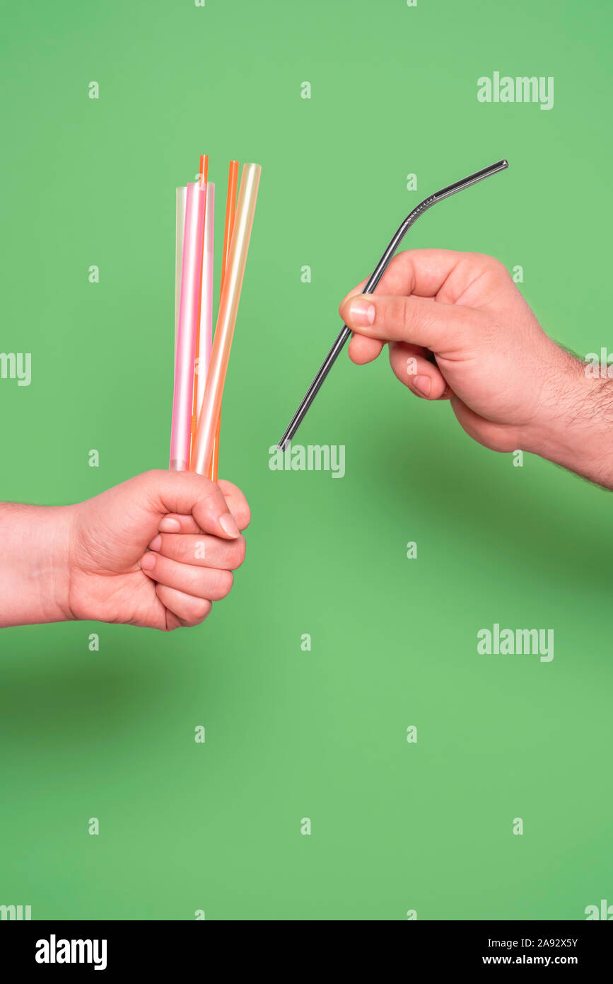 Man choosing a metal straw from many plastic straws. Zero waste concept. Ecofriendly drinking