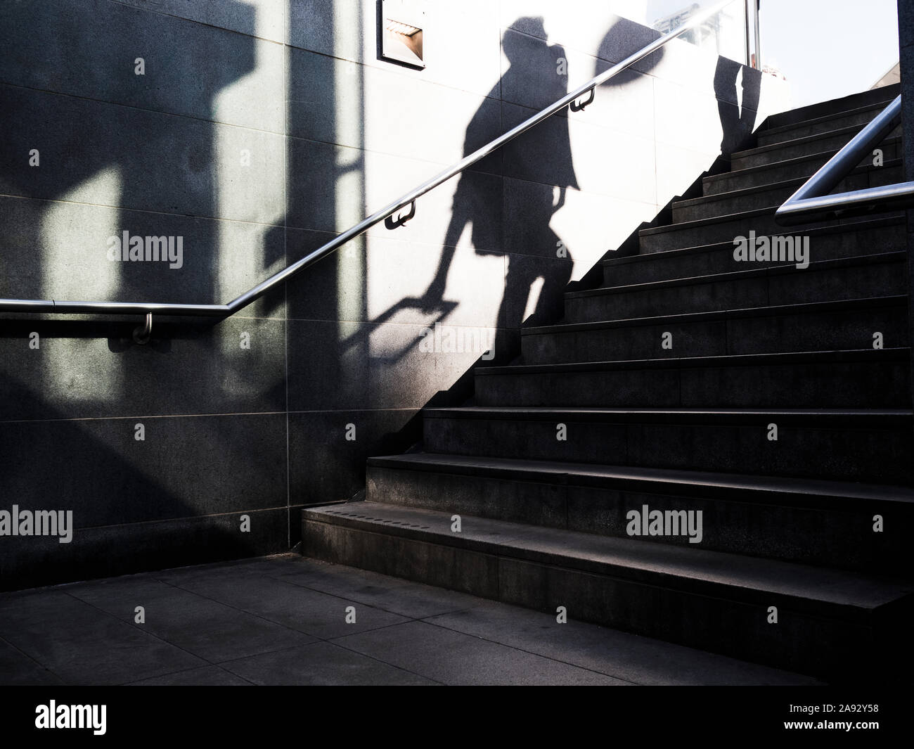 Shadow of person walking up stairs Stock Photo