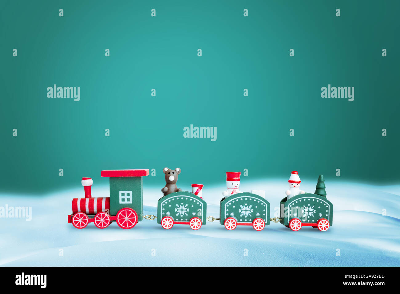 Green train in snow. Copy space above on green background for greeting text. Christmas, New Year greeting card concept. Stock Photo