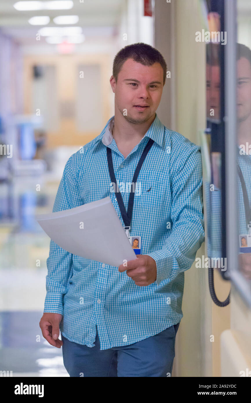 Young man with Down Syndrome doing paperwork in a hospital Stock Photo